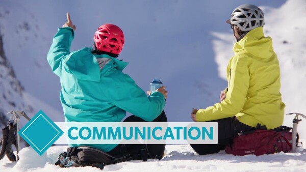 2 alpinists discussing safe travel while taking a break in the mountains