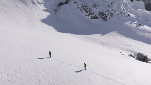 Drone shot of 2 alpinist traversing a slope in the backcountry